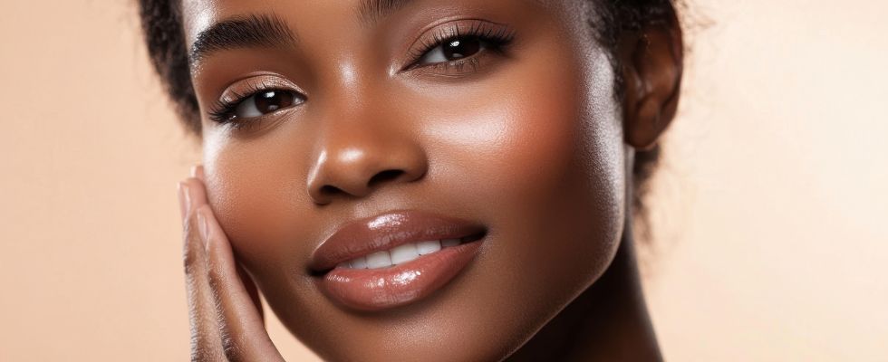A woman with dark skin admires her face and skin after a med spa treatment in milwaukee
